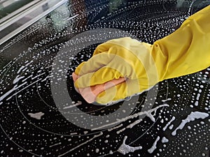 Hand in yellow glove washes electric stove