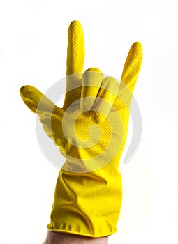 A hand in yellow rubber gloves shows a rock horn, two fingers up on a white