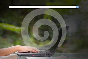 Hand of young business woman typing using laptop computer digital information with blank search bar.