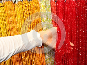 Hand of Young girl amidst sparkling crystal necklaces photo