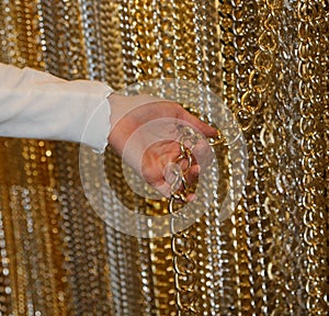 hand of a young girl while she is choosing a golden chain to create a personalized necklace