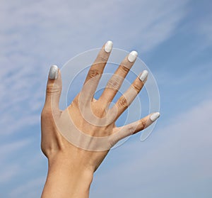 hand of young girl with five fingernail with colored nail polish