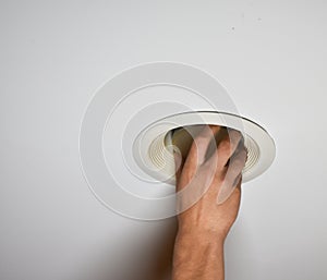 Hand of young man changing a compact flourescent light bulb