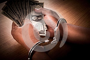 Hand young man in handcuffed hold money