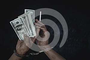 Hand young man in handcuffed hold money, Police arrest drug trafficker with handcuffs. Law and police concept