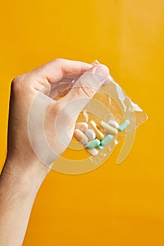 Hand of a young man holding a pills