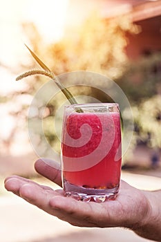 Hand of young man holding watermelon soda cocktails in sunny day