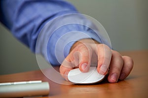 Hand of a young man on the keyboard and computer mouse close-up with depth of field