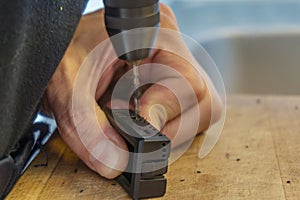 Hand of a young man repair hygrometer with a screwdriver at home