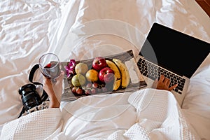 The hand of Young woman that hold wine glass And Sit play laptop In a luxurious room Ready Fruit