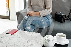 The hand of a young woman holding a smart phone and a modern Power Bank charger. Put it at the desk, charging the smartphone with