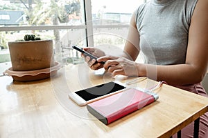 The hand of a young woman holding a smartphone and a modern spare battery charger Place the lap to charge the smartphone with a