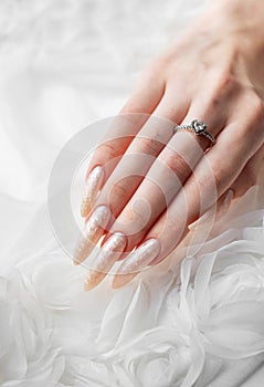 Hand of a young woman with white pearl manicure