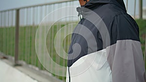 Hand zipping sport jacket on street closeup. Fitness man training in morning
