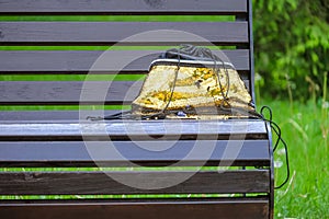 Handbag with golden sequins forgotten on a street bench