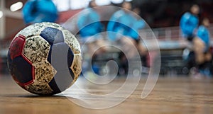 Handball ball on floor. Blurred exercising team background. Space for text. photo