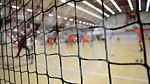 Handball match scene with goalpost and goalkeeper and players attacking in the background