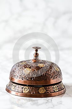 Handcrafted Cupper Service Desk Bell on Marble Background photo