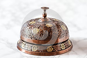 Handcrafted Cupper Service Desk Bell on Marble Background photo