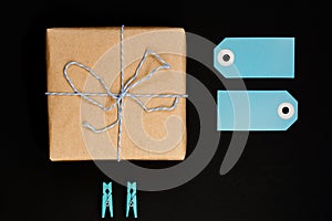 Handcrafted gift boxes wrapped in Craft paper  with blue paper card tag, rope and wooden  clothespins for decoration