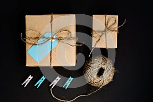 Handcrafted gift boxes wrapped in Craft paper  with blue paper card tag, rope and wooden  clothespins for decoration