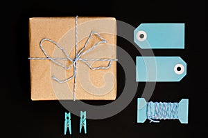 Handcrafted gift boxes wrapped in Craft paper  with blue paper card tag, rope and wooden  clothespins for decoration