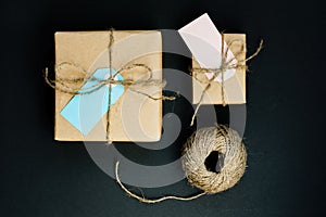 Handcrafted gift boxes wrapped in Craft paper with blue and pink paper card tag, rope and wooden clothespins for decoration