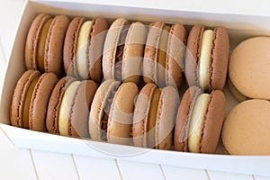 Handcrafted Macarons in Natural Tones, Unadorned by Colorants in two rows inside white paper box photo