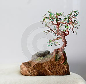 Handcrafted and painted wire tree for spring  attached to rock