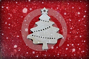 Handcrafted wooden Christmas Tree on red textured background, falling snowflakes, new year greeting