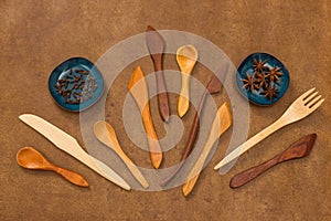 Handcrafted wooden utensils and spices on leather background