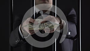 Handcuffed businessman holding dollar banknotes, tax evasion, money laundering