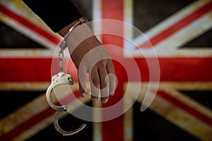 Handcuffed hand in front of the country flag. crime concept