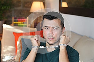Handcuffed young man in the sofa