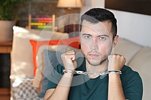 Handcuffed young man in the sofa