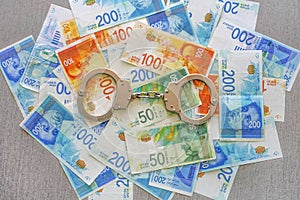 Handcuffs on the background of the money of shekels
