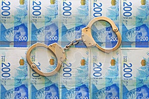Handcuffs on the background of the money of shekels