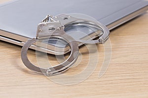 Handcuffs on a closed laptop computer