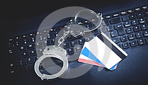 Handcuffs with credit cards on computer keyboard. Concept of Cyber crime and Online fraud