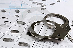 Handcuffs and fingerprint record sheets, closeup