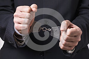 Handcuffs on the hands of an office employee. Arrest Concept