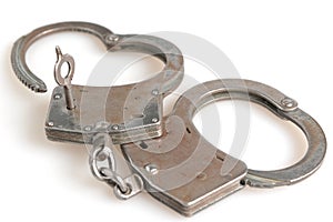 Handcuffs in heart shape and key within isolated