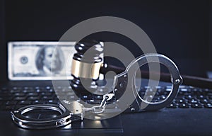 Handcuffs and Judge Gavel on laptop keyboard. Concept of  Cyber crime and Online fraud