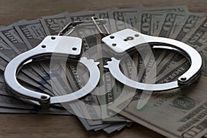 Handcuffs lie on hundred dollar bills, Concept: arrest and corruption in power.