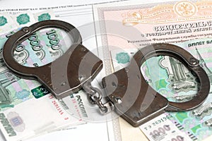 Handcuffs and money against the background of the certificate of