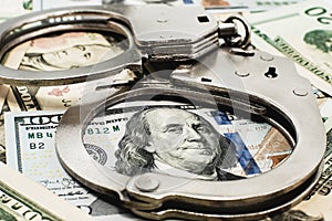 Handcuffs and money close-up. Financial fraud and crime. Handcuffs. Law and order