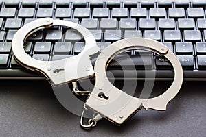 A handcuffs standing on computer keyboard.