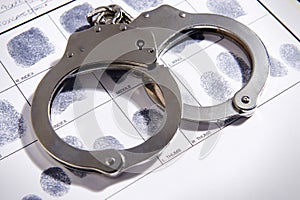 Handcuffs on top of a set of fingerprints