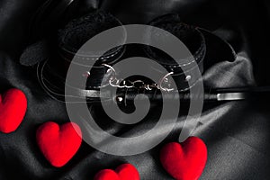 Handcuffs and whip for BDSM sex with red hearts.