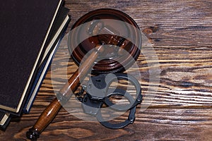 Handcuffs and a wooden gavel in front of manila folders